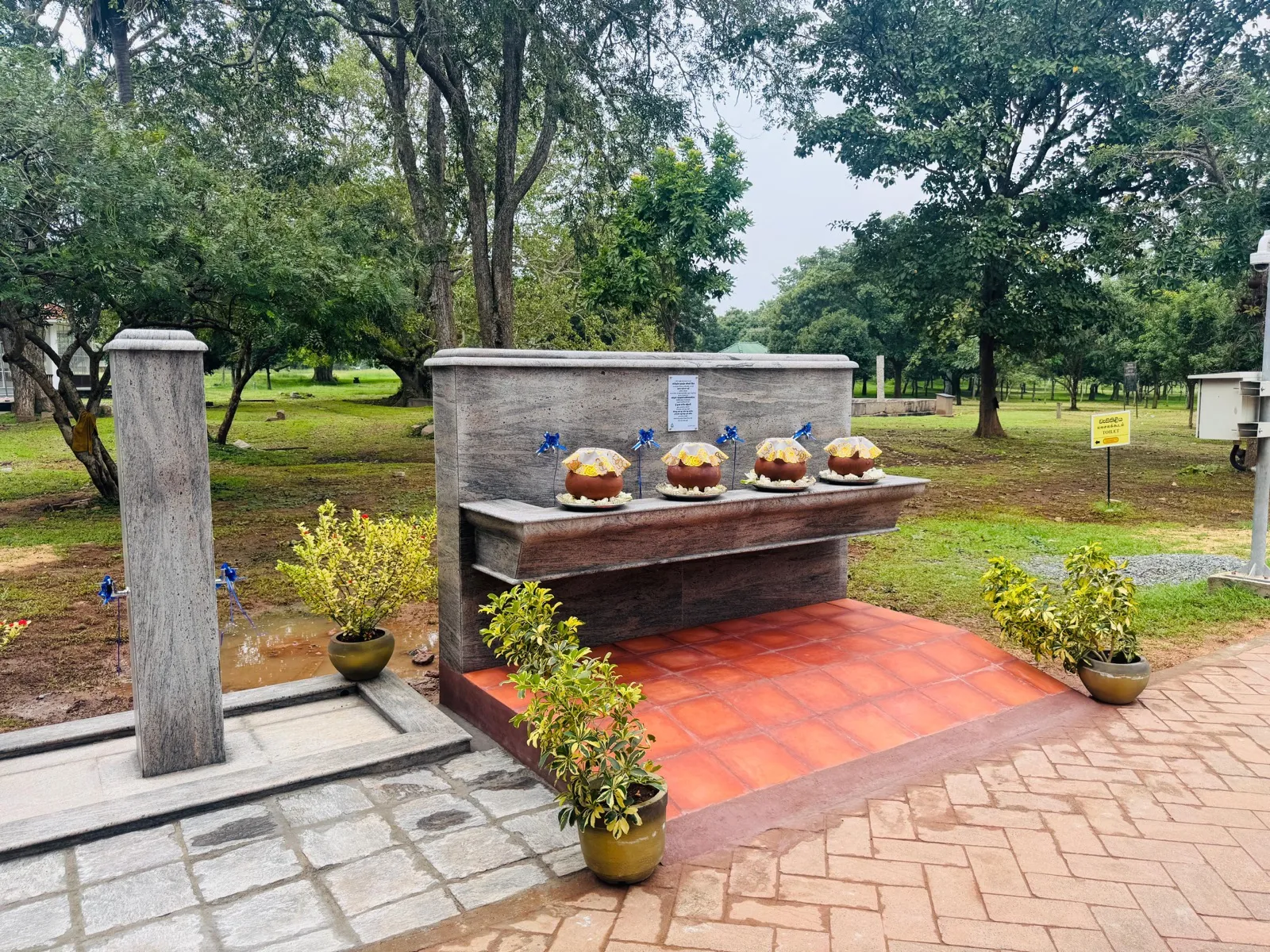 Alms-giving memorial structure in a park following Cyclone Ditwah