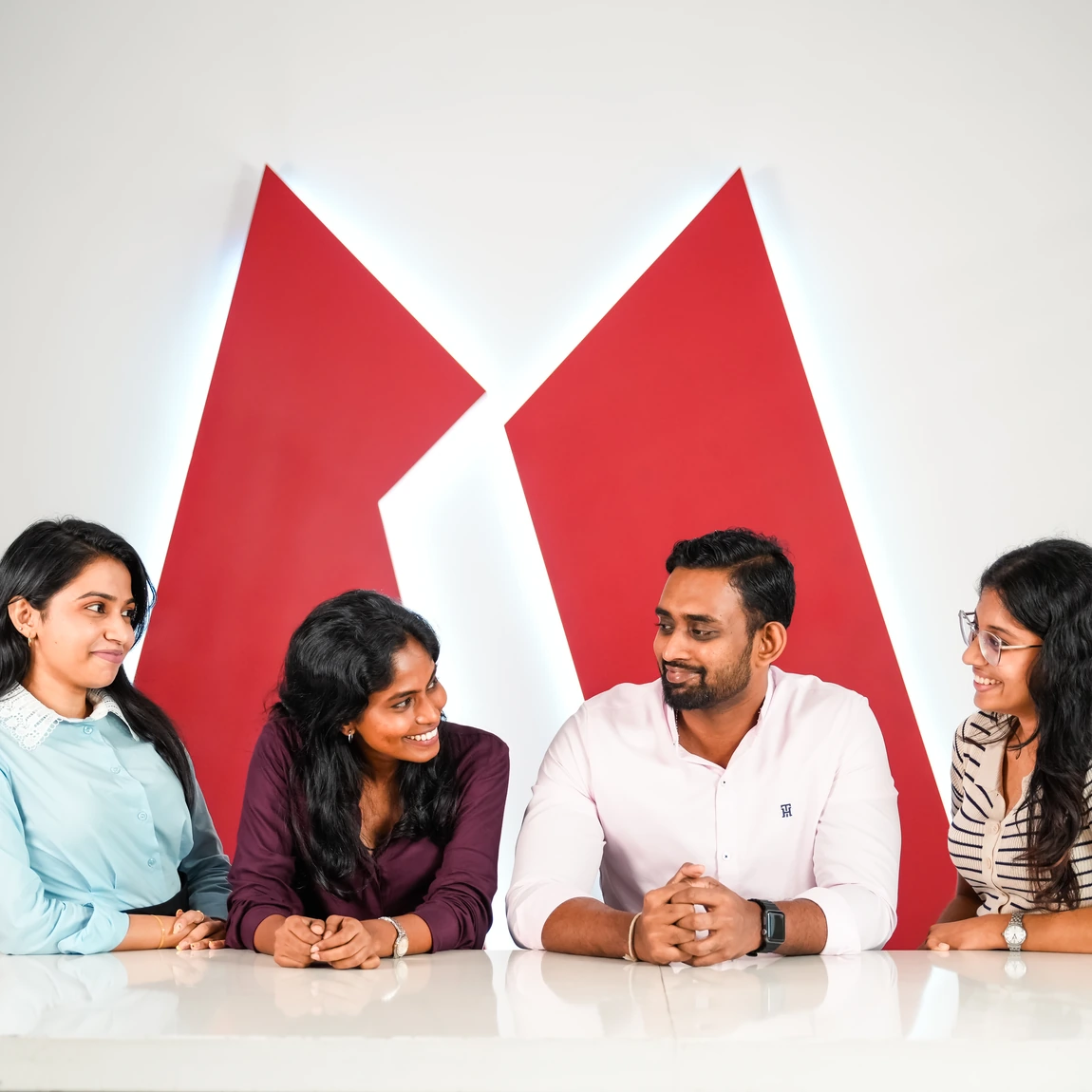 MAS employees at an entrepreneurship session beside the MAS logo wall