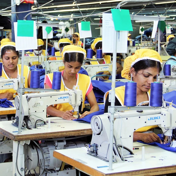 MAS women employees in yellow tops working at a sewing line