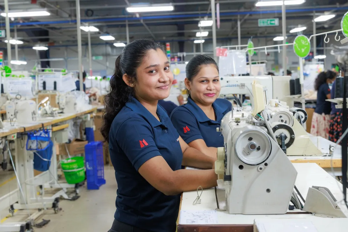 Two MAS women employees at sewing machines on the factory floor