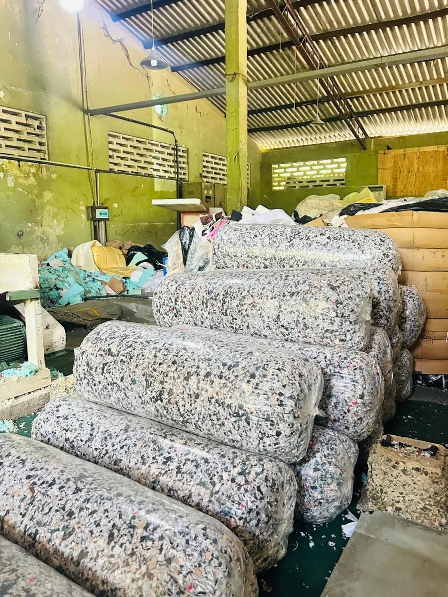 Baled, compressed recycled foam and textile offcuts stacked in a recycling and baling storage area