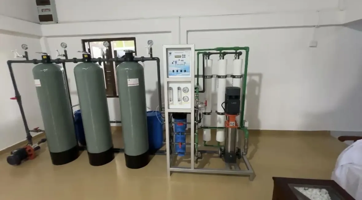 Reverse-osmosis water-treatment plant — green pressure-filter tanks and an RO skid with control panel in a MAS facility